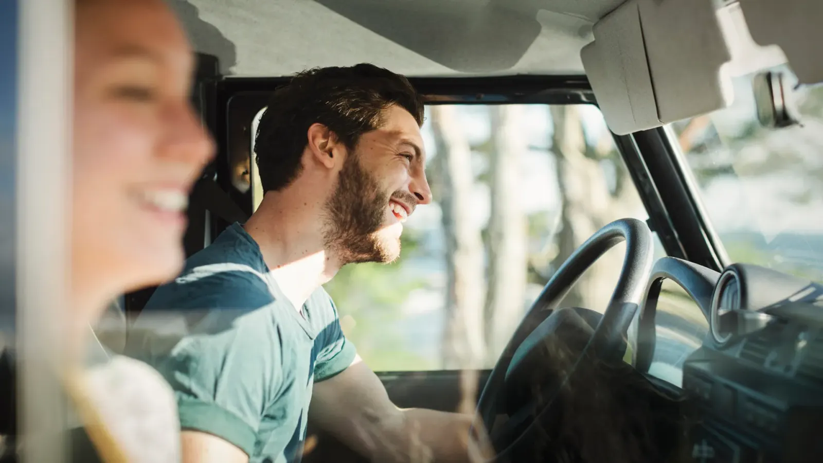 Two Mpya Finance colleagues smiling during a car ride on a sunny day